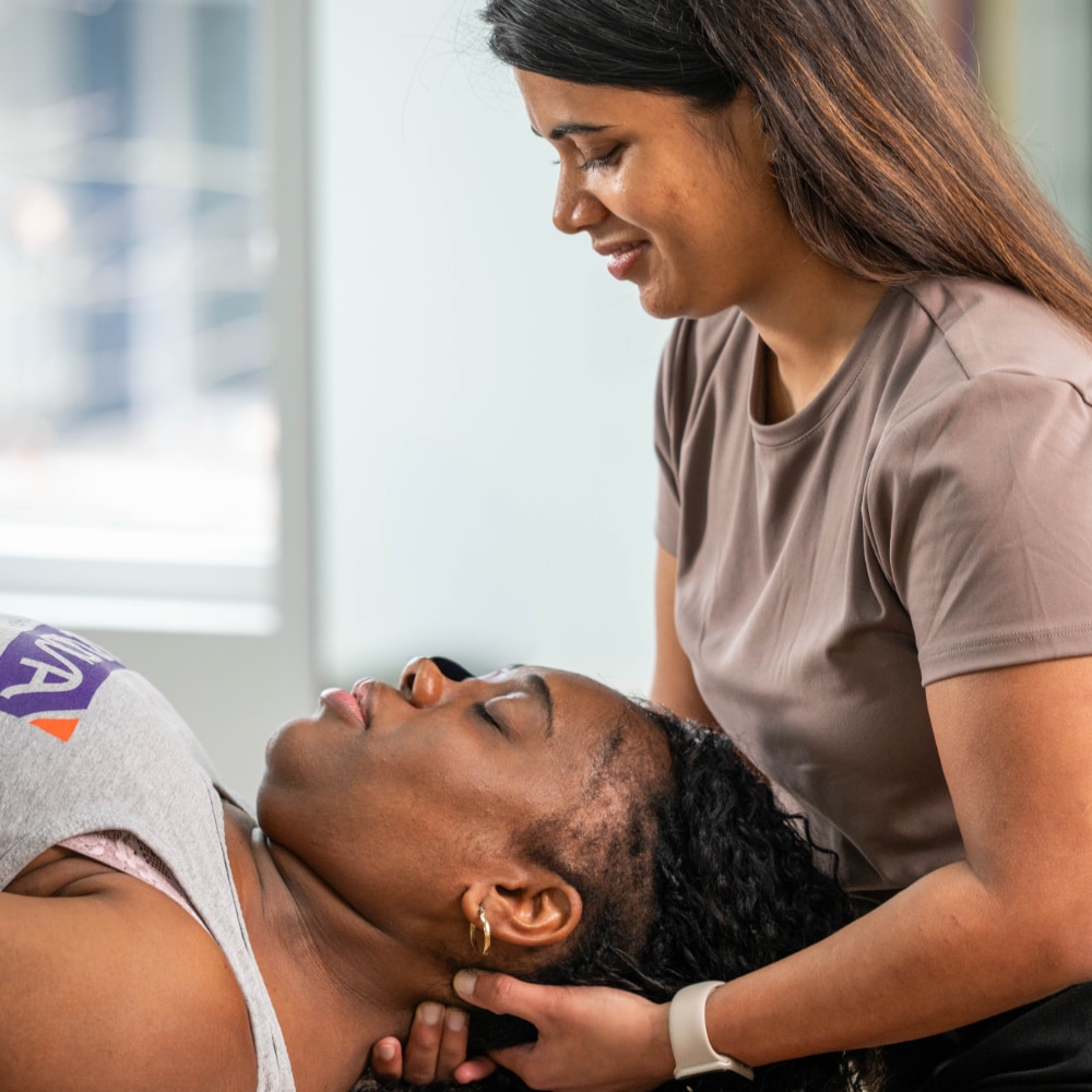 A therapist massages a patient's neck